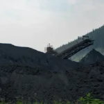 Fasilitas pengolahan batubara industri dengan tumpukan batu bara besar di area penambangan